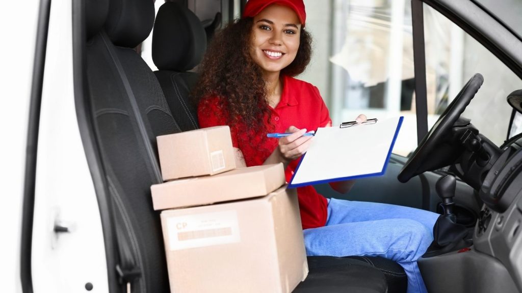 mulher em cabine de carro com caixas de entrega.