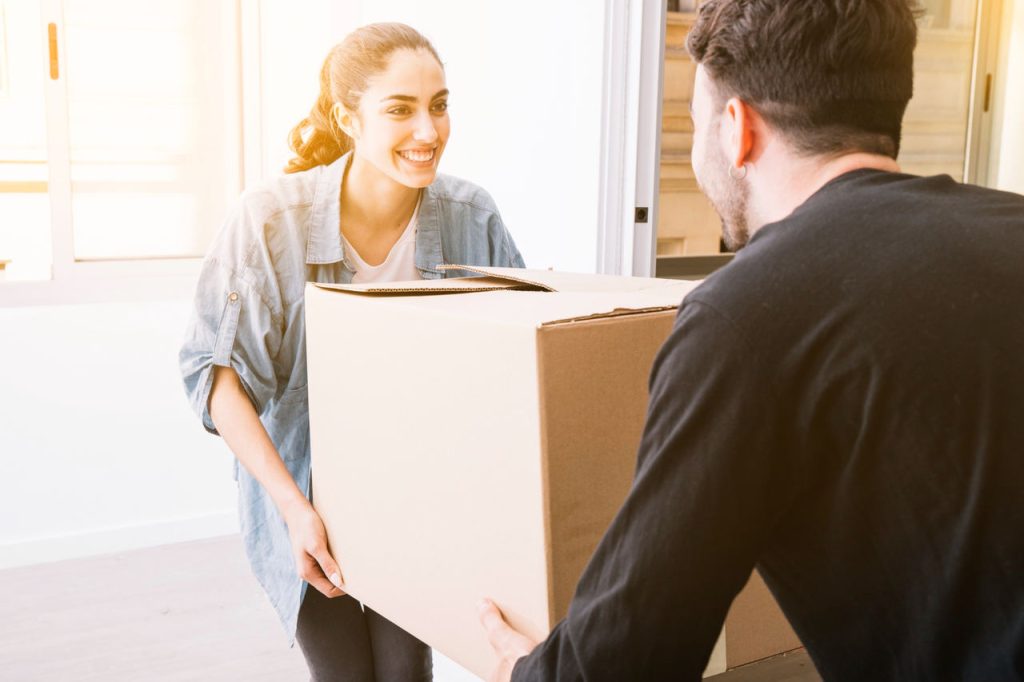casal carregando caixa de mudança