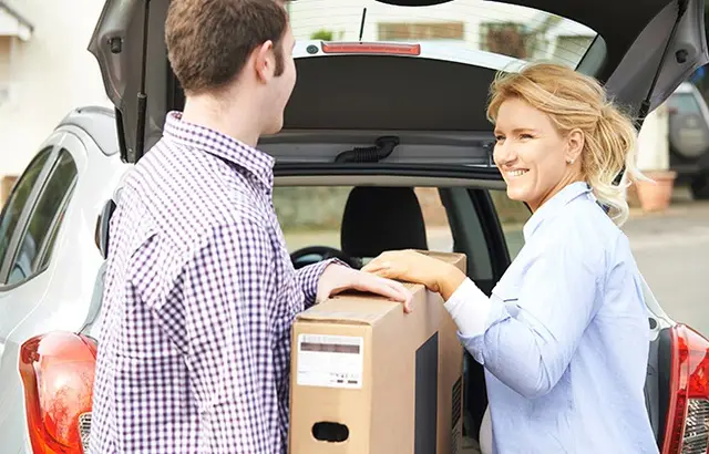 como transportar TV: casal colocando TV no carro