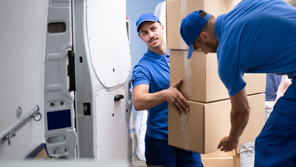 Carregadores de mudança transportando caixas.