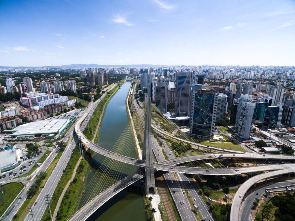 Mudança para São Paulo: foto aérea das vias de São Paulo que passam ao lado e por cima de um rio.