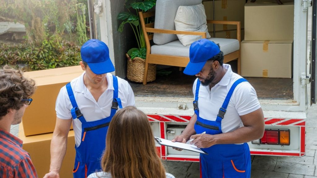 Dois funcionário de empresa de mudança conferindo lista com a cliente.